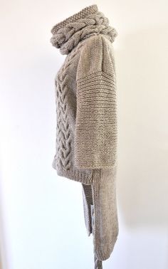 a knitted coat hanging on the wall