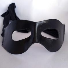 This is a variant of our popular black leather mask, now with a wider design to fit the look of other classic characters! This classic wrap around mask is a great finishing touch for many costumes. Made of molded leather, it fits comfortably to your face and will fit better as you wear it. The ties are stretchy fabric, so it'll fit to your head. The leather gives a great structured look, while the fabric makes it look like the whole thing wraps around while staying comfortable and adjustable.Add Superhero Black Masks And Prosthetics For Halloween, Adjustable Black Eye Mask Costume Accessory, Adjustable Black Eye Mask For Costumes, Black Full Face Masks For Costume, Black Full Face Masks For Costumes, Black Full Face Masquerade Costume Accessories, Black Full Face Masquerade Accessories, Full Face Black Costume Mask, Adjustable Black Masks And Prosthetics For Masquerade