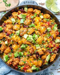 a skillet filled with chicken, beans and avocado