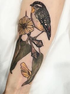 a bird sitting on top of a plant with yellow flowers around it's legs