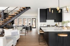 an open concept kitchen and living room with stairs