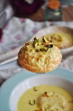 there is a bowl of soup and a biscuit on the table