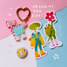 some stickers and magnets are on a colorful surface with a heart shaped keychain