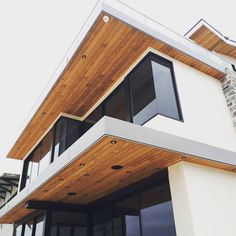 a modern house with wood and glass on the roof