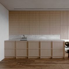 an empty kitchen with wooden cabinets and white counter tops, along with a potted plant