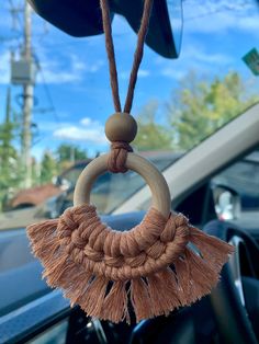 a car dashboard with a wooden ring and tassel hanging from it's center console