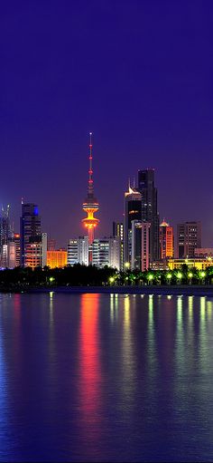 the city skyline is lit up at night with bright lights on it's skyscrapers