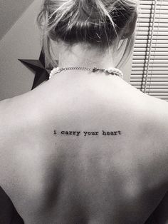 a woman with a tattoo on her back saying i carry your heart