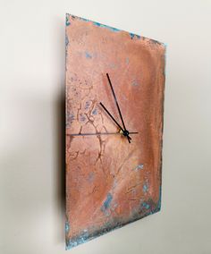 a clock that is on the side of a wall with blue paint and black hands