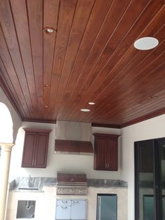 a kitchen with wooden ceiling and appliances in it