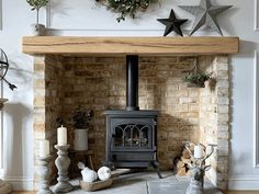 a wood burning stove sitting in a living room next to a fire place and christmas decorations