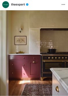 an image of a kitchen setting with red cabinets and white counter tops, including a stove