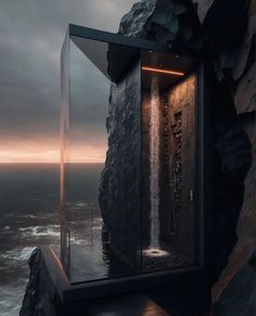 an outdoor shower in the shape of a house on top of a cliff by the ocean