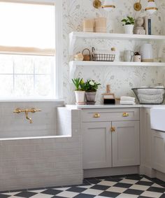 a kitchen with white cabinets and black and white checkered flooring on the walls