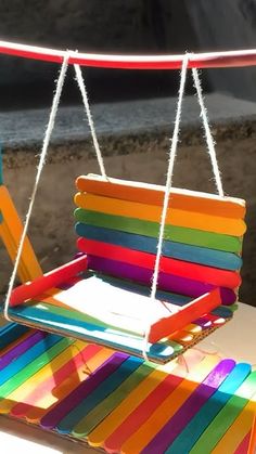 a rainbow colored swinging chair on the beach