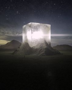 a large white cube sitting on top of a mountain under a sky filled with stars