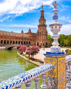 an ornate fountain in front of a building with a clock tower on it's side