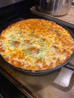 a cheesy pizza sitting on top of a stove