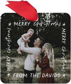 a merry christmas card with an image of a man and woman holding a baby in their arms