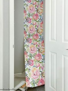 an open door with a pink flowered curtain hanging from it's side in front of a doorway