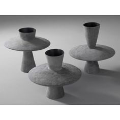 three cement vases sitting on top of each other