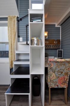 a room with a desk, chair and shelves on the wall next to each other