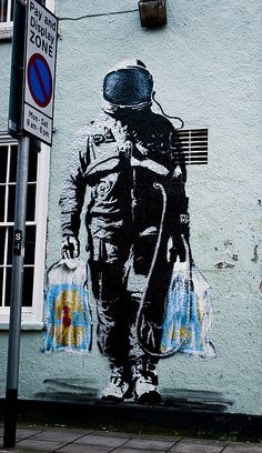 a painting on the side of a building with a man in space suit and helmet