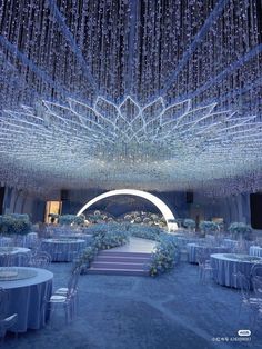 an elaborately decorated wedding venue with chandeliers and blue linens on the ceiling