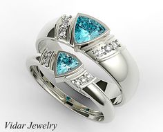 two wedding rings with blue topazte and diamonds on each side, set in white gold