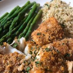 a white plate topped with meat, rice and asparagus next to green beans