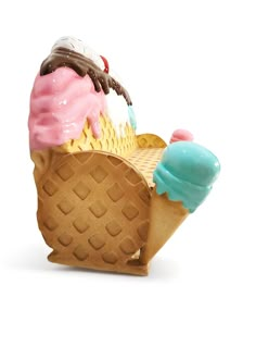 an ice cream sundae with pink, blue and green toppings on it's cone