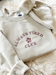 Embroidered Always Tired Club New Mom Gift Sweater - Embroidered - Unisex Crewneck Sweatshirt - Designed with pre-shrunk soft air-jet spun yarn - Loose fit for a comfortable feel * Sizing and Colors - Please refer to sizing and color charts in the images * Fabrication - 50% cotton, 50% polyester * Care Instructions - Turn inside out and machine wash cold on delicate cycle - Dry on low heat setting - Do not bleach - Do not dry clean - Do not iron directly on design * Processing and Shipping Times - Please allow 4-10 business days for your order to be processed and stitched - Standard shipping takes 3-5 days - Please note that these times are estimated by USPS and may take longer - Please make sure your shipping address is correct before placing an order - Stitched and Shipped in the USA * R Trending Crewneck Designs, Simple Embroidered Sweatshirt, Sweater Ideas Design, Iron On Sweatshirt Ideas, Embroided Hoodie, Etsy Sweatshirts, Trendy Crewneck Sweatshirt, Cute Crewneck Sweatshirt, Trendy Crewneck