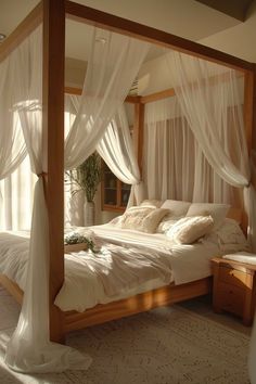 a bed with white drapes and pillows on it