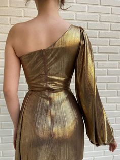 Details:-Gold colour-Shiny lacquer fabric-Waist definition with one sleeve and open skirt-For special occasions