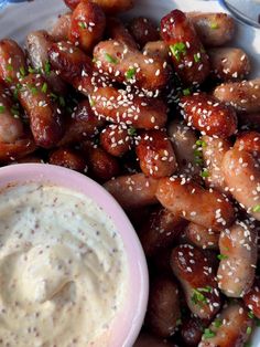 a white plate topped with chicken wings next to a bowl of ranch dressing on top of it