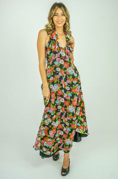 "DESCRIPTION Gorgeous Vintage 70's Pretty Floral Ruffle V Neck Halter Maxi Dress Light Weight Semi Sheer Black Fabric with a Beautiful Floral Print in Pink, Red, Turquoise, Green and White. Slip over the Head Construction with an Empire Waistline and V Halter Neckline with Wide Ruffle and Back of Neck Hook n Eye Closure. Fitted Darted Bust and Scooped Back. Long A Line Maxi Length Body and Back Zip Closure. Lined in Black Acetate. DETAILS: Fabric : Rayon Crepe Label : Kati by Laura Phillips Era : 1970's Condition : Quite Good but has had some patches/mends. Price reflects condition and dress is Sold as Is. MEASUREMENTS: Bust : 32\" A, B cup Max Empire Waist : 28\" Max Hip : 40 Max\" Length : 55\" Approximately Gentle Hand Wash Cool" Black Retro Maxi Dress For Spring, Head Construction, Empire Waistline, Halter Maxi Dress, Halter Maxi, Halter Maxi Dresses, Halterneck Dress, Floral Ruffle, Halter Neckline