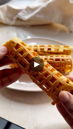 a person is holding waffles on a plate