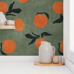 an orange and green wallpaper with two vases on the counter next to it