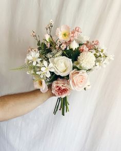 a person holding a bouquet of flowers in their hand