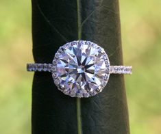 a diamond ring sitting on top of a leaf