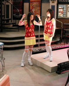 two young women standing on top of a stage