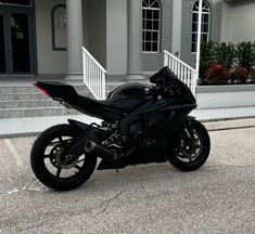 a black motorcycle is parked in front of a large building with steps leading up to it