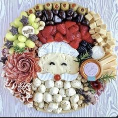 a platter filled with cheese, fruit and vegetables