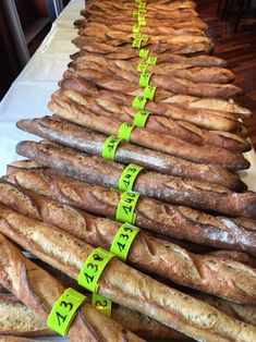 several rows of breads are lined up on a table with yellow tape around them