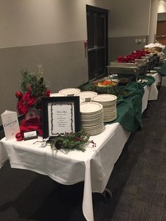 a long table with plates and food on it in the middle of a banquet hall