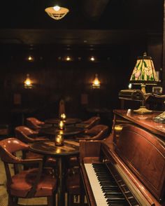 an old piano and some chairs in a room