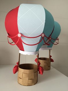 two hot air balloons are sitting on top of cardboard boxes and tied to the sides