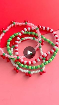 three beaded bracelets on top of a pink surface