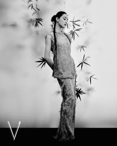 a woman standing in front of bamboo leaves