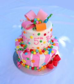 a birthday cake decorated with candy and bows